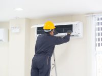 The mechanic Technician are Repairing Air Conditioner in room.